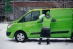 Grönklätt bud vid grön Bring-transportbil