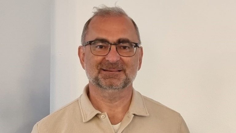 Porträttbild av man med glasögon och vit tröja