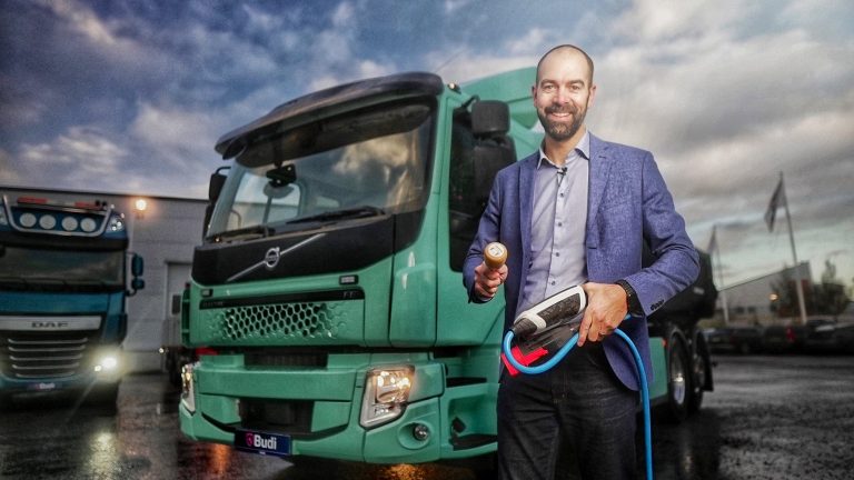 Auktionsförrättare framför en begagnad ellastbil till salu.
