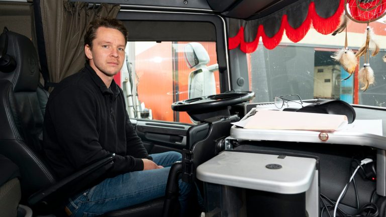 Lastbilsförare framför ratten i lastbil