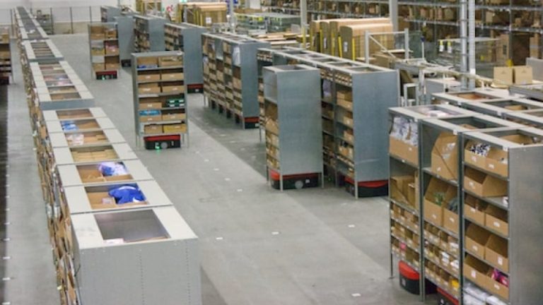 Autotruckarna flyttar fram de mobila hyllorna till plockstationerna. Mänskliga plockare är inte tillåtna i det avspärrade området.