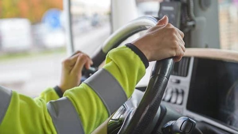 En lastbilsförares händer greppar om en ratt En lastbilsförares händer greppar om en ratt