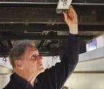 Gunnar Asplund, innovatör och vd för Elways, visar hur en rörlig arm under bilen känner av var skenan är.